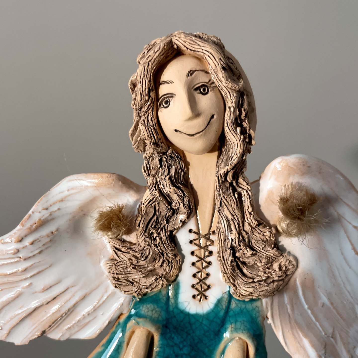 Handmade pottery angel sculpture with white wings and turquoise dress
