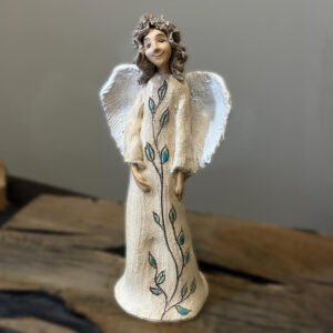 White angel ceramic sculpture handmade from chamotte clay on rustic wooden shelf