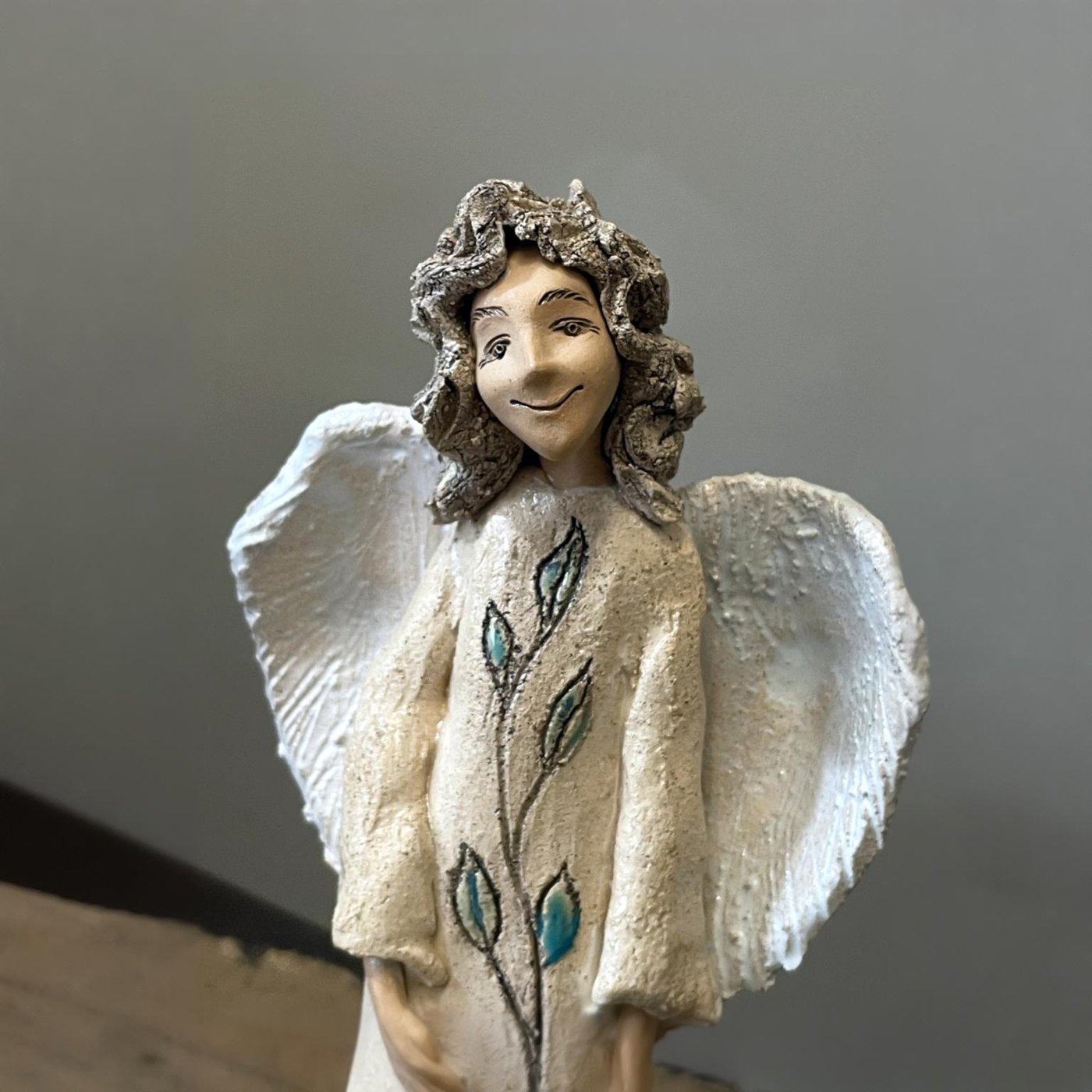 Stoneware angel figurine with white wings and natural ceramic texture