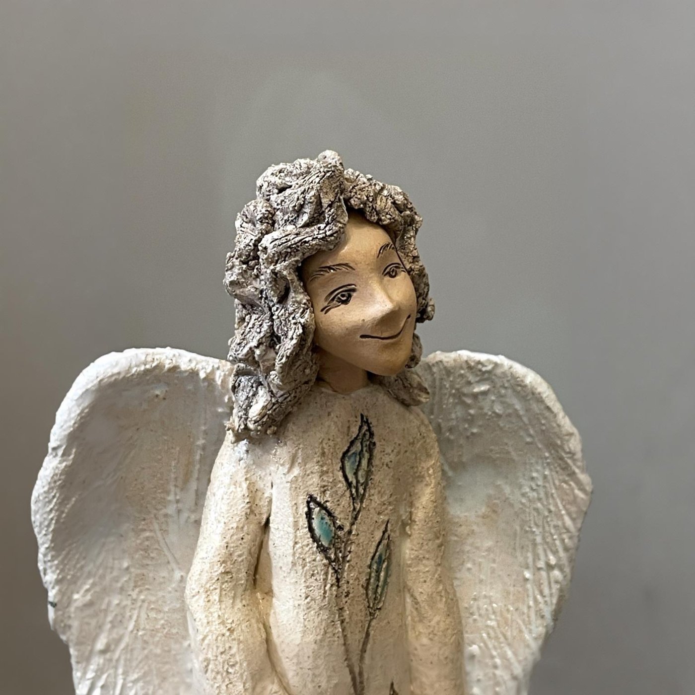 White angel pottery sculpture with sculpted wings and peaceful expression