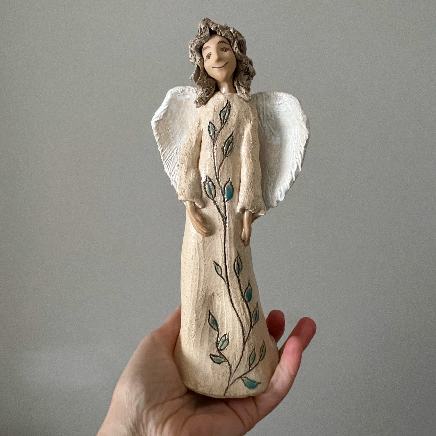 Artisan ceramic angel made from chamotte clay with decorative leaves