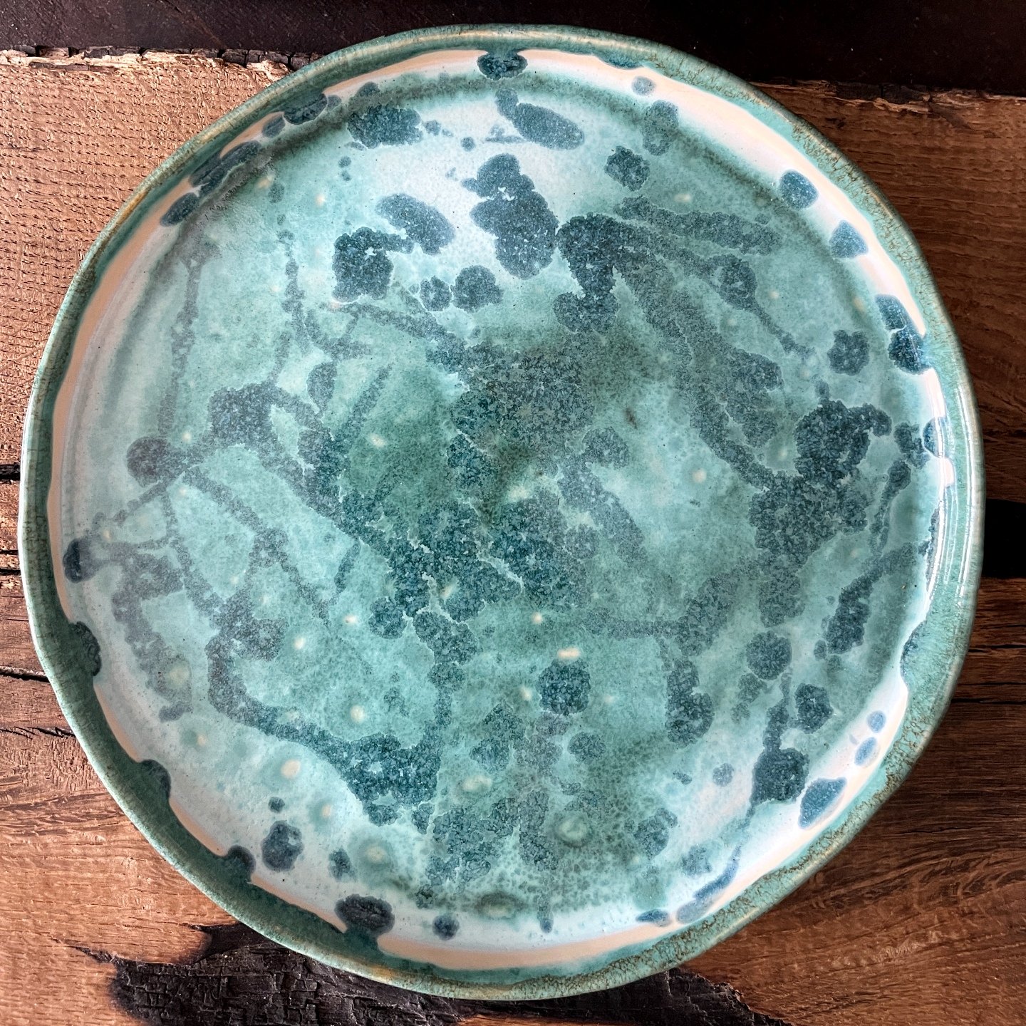 Close up of turquoise ceramic plate with unique glaze texture