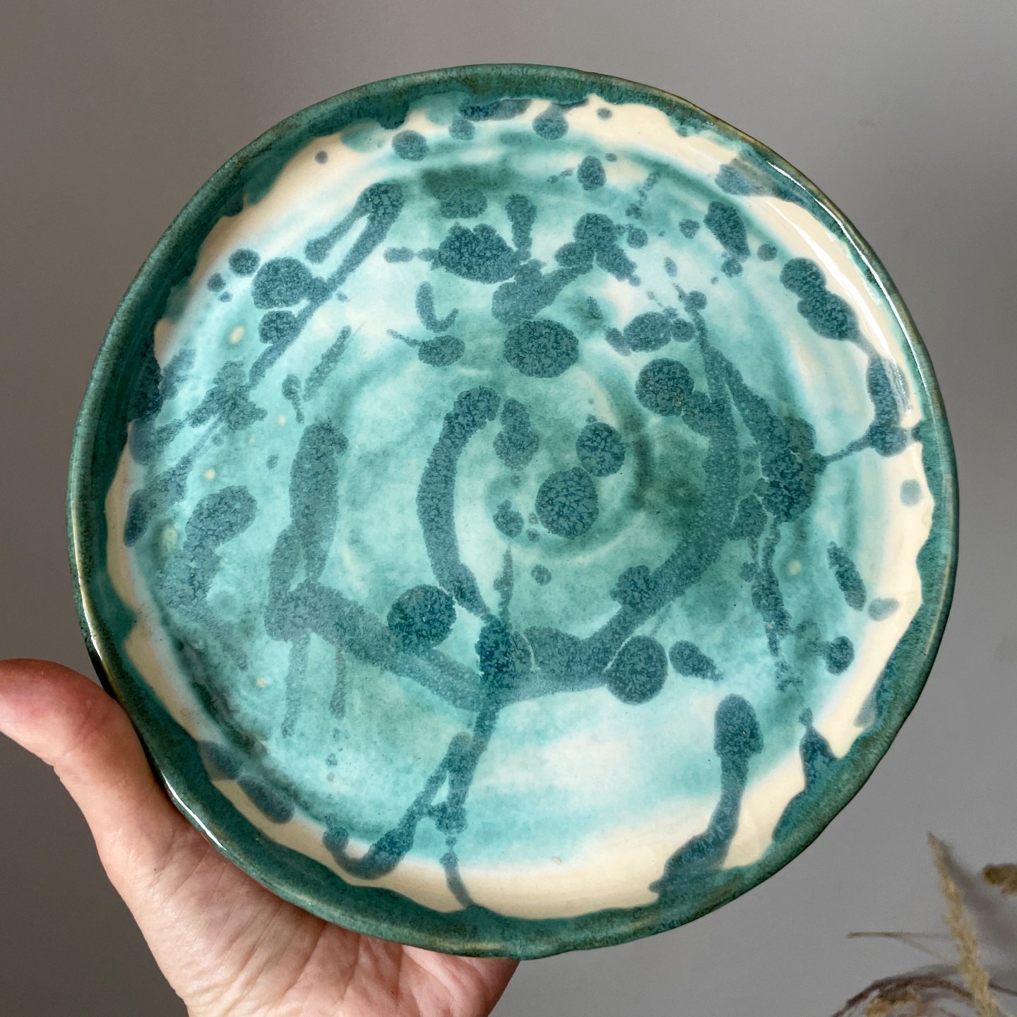 Close up of handmade ceramic plate with blue glaze pattern
