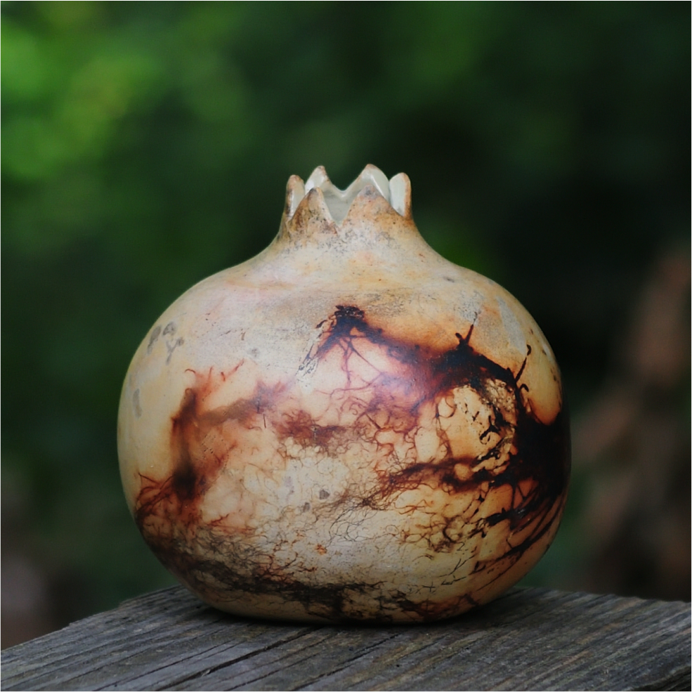 Decorative pomegranate ceramic vase styled as home decor on shelf