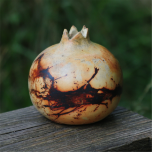 Pomegranate saggar ceramic vase with abstract smoke patterns on wood