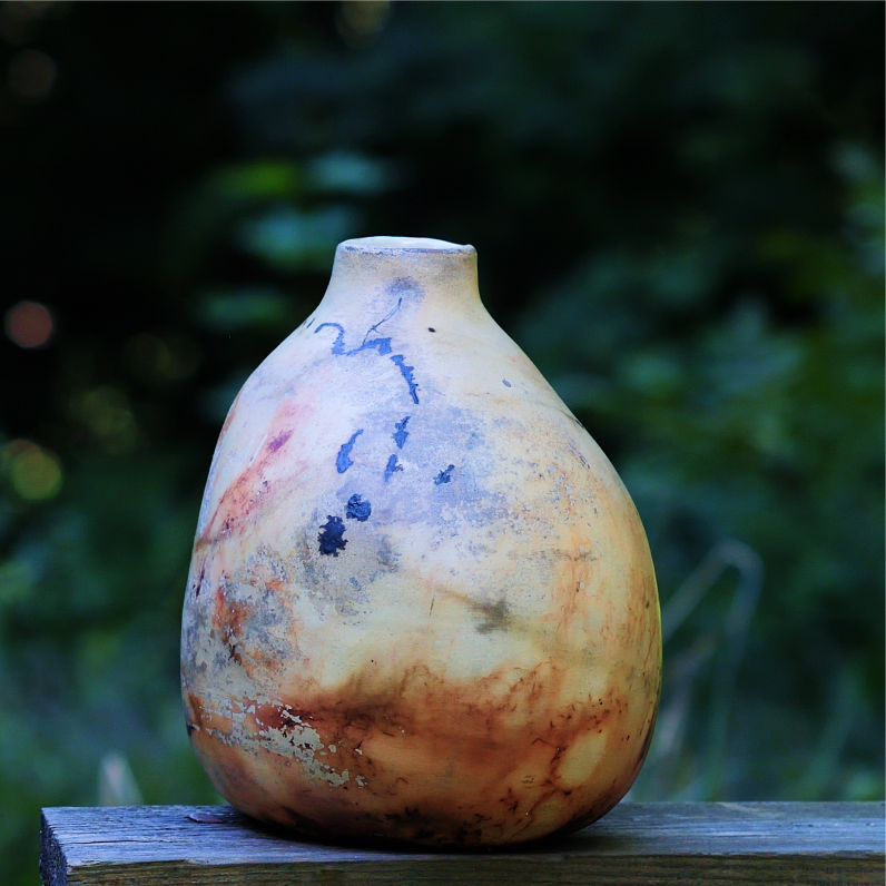 Ceramic vase with abstract smoke designs in cream, orange and black colors.
