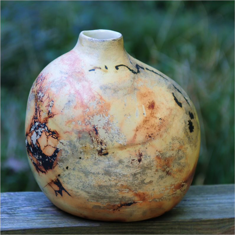 Artisan saggar vase photographed in natural light, showcasing warm tones of fire marks.