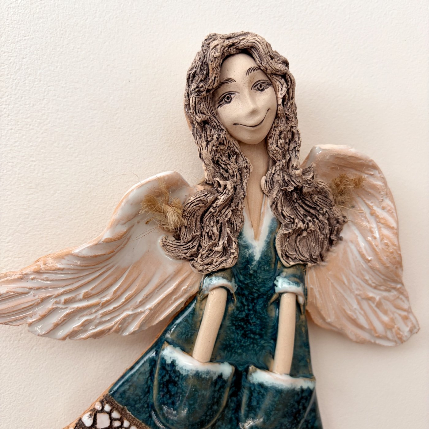 lose-up of ceramic angel face with sculpted wavy hair