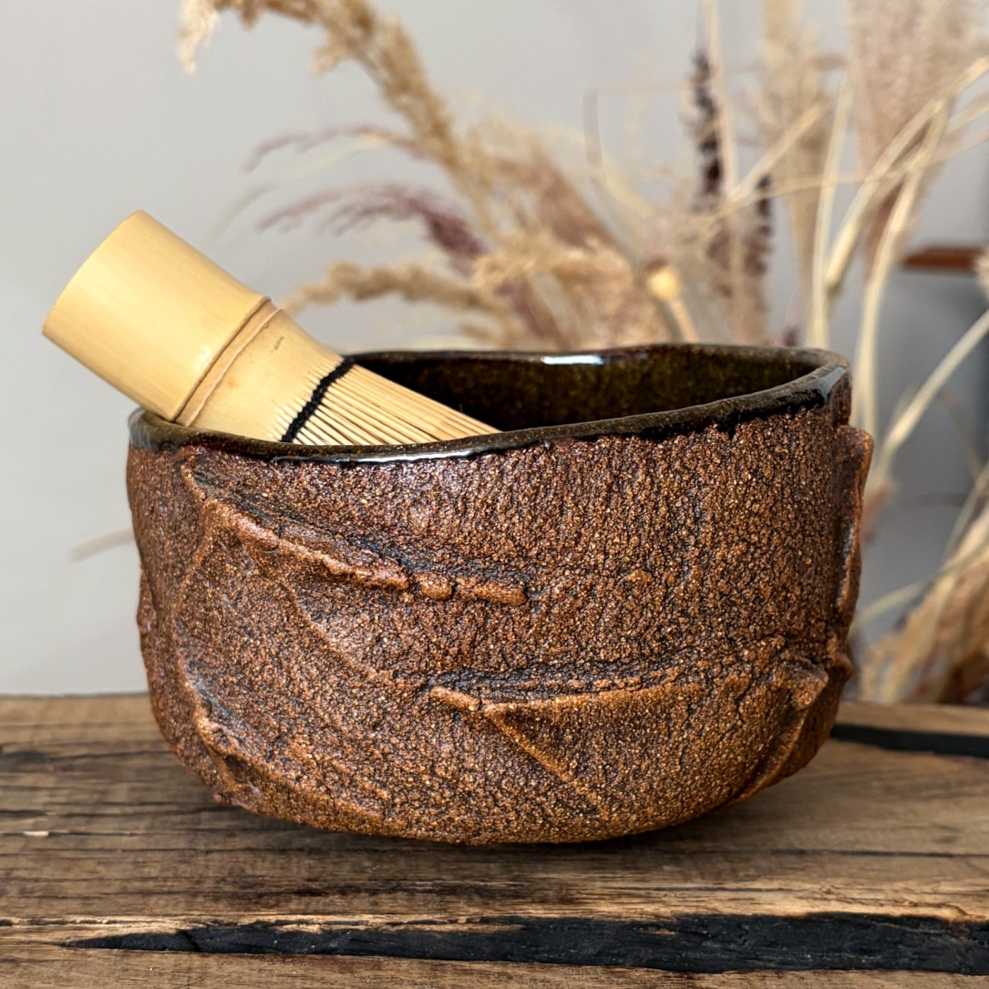 Ceramic matcha bowl with bamboo whisk and textured exterior