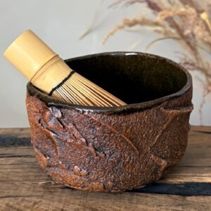 Handmade chawan with matcha whisk and rustic pottery texture