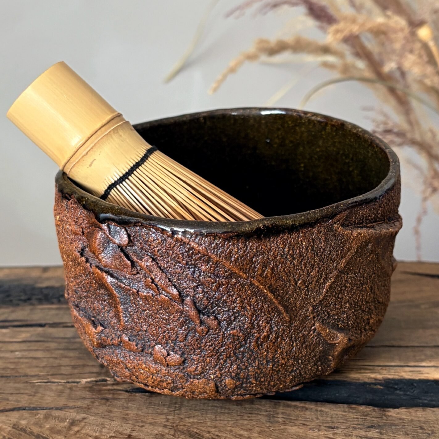 Handmade chawan with matcha whisk and rustic pottery texture
