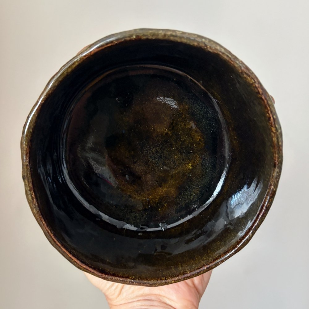 Top view of rustic pottery matcha bowl with dark interior glaze