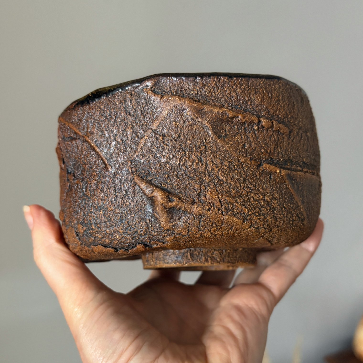 Handcrafted ceramic chawan showing textured brown exterior