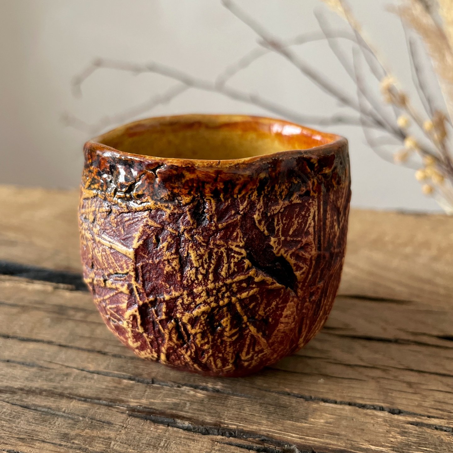 Small stoneware yunomi tea cup in warm brown and red glaze