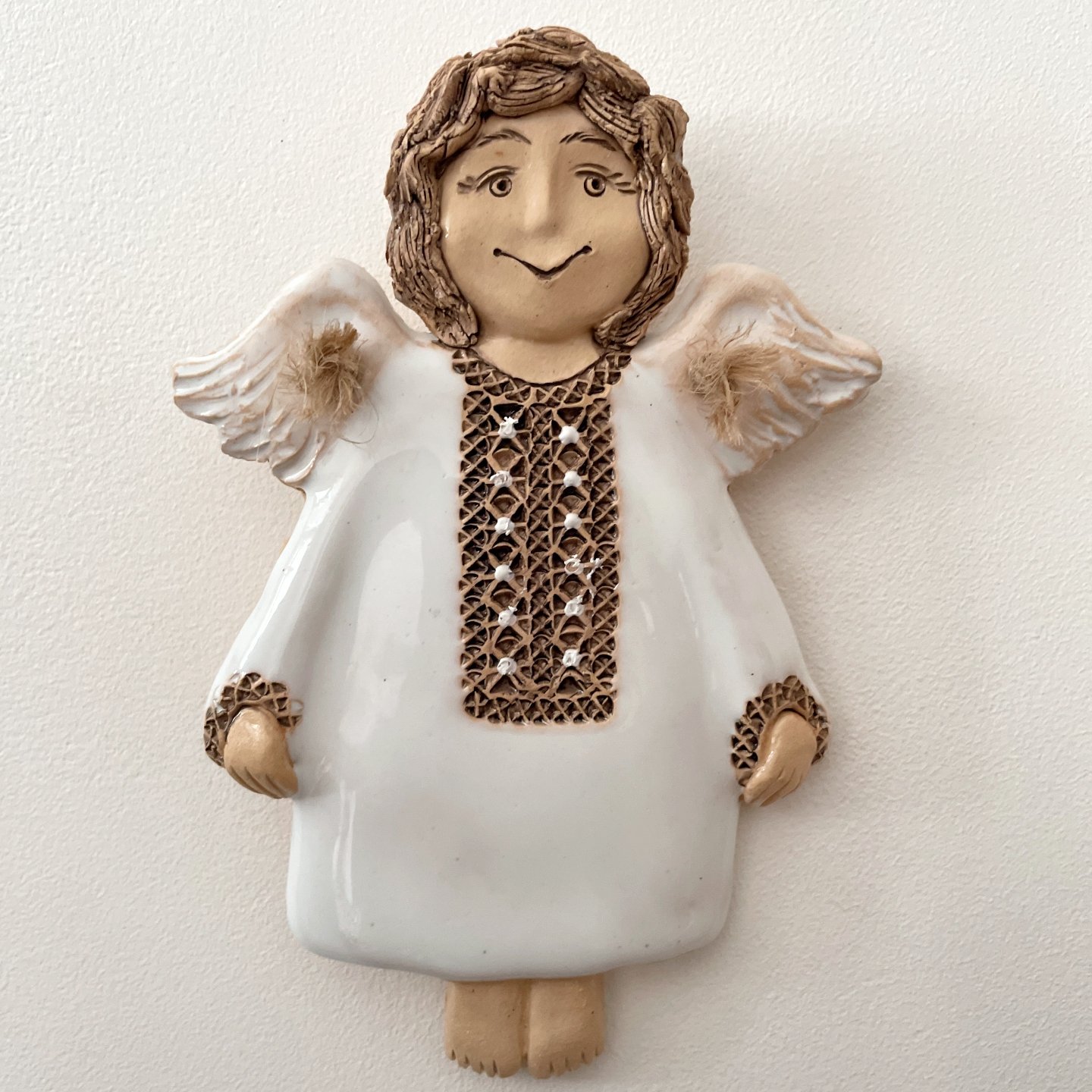 Handcrafted angel wall hanging with textured brown pattern