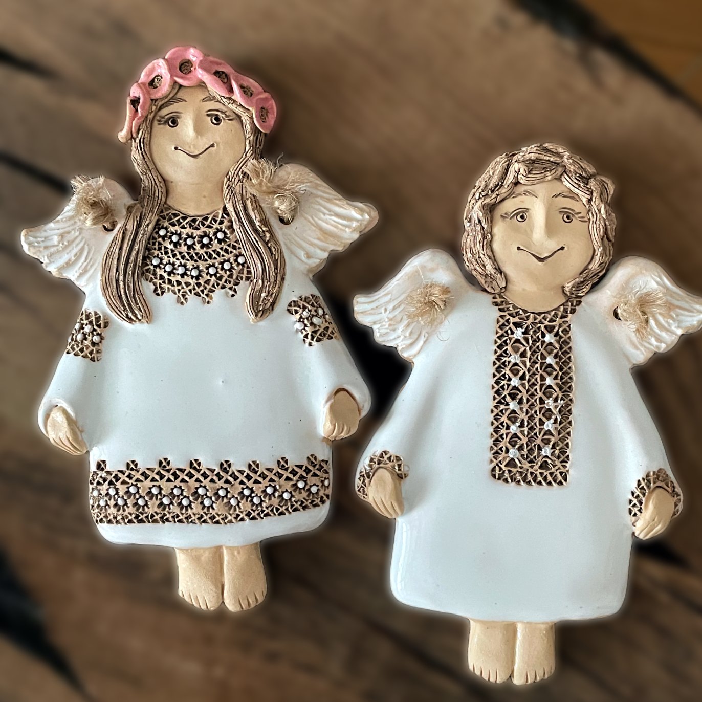 Two ceramic angel wall ornaments displayed together