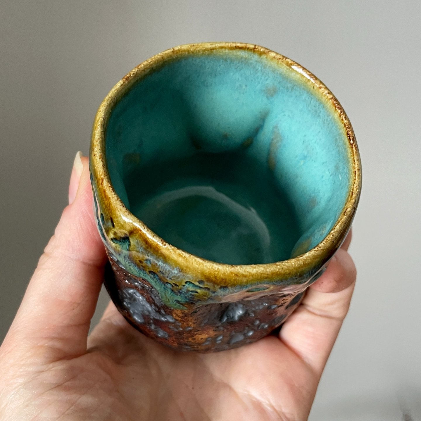 Top view of handmade ceramic cup with turquoise glazed interior