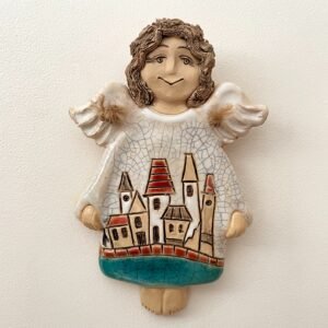 Front view of handmade ceramic wall angel with little town design