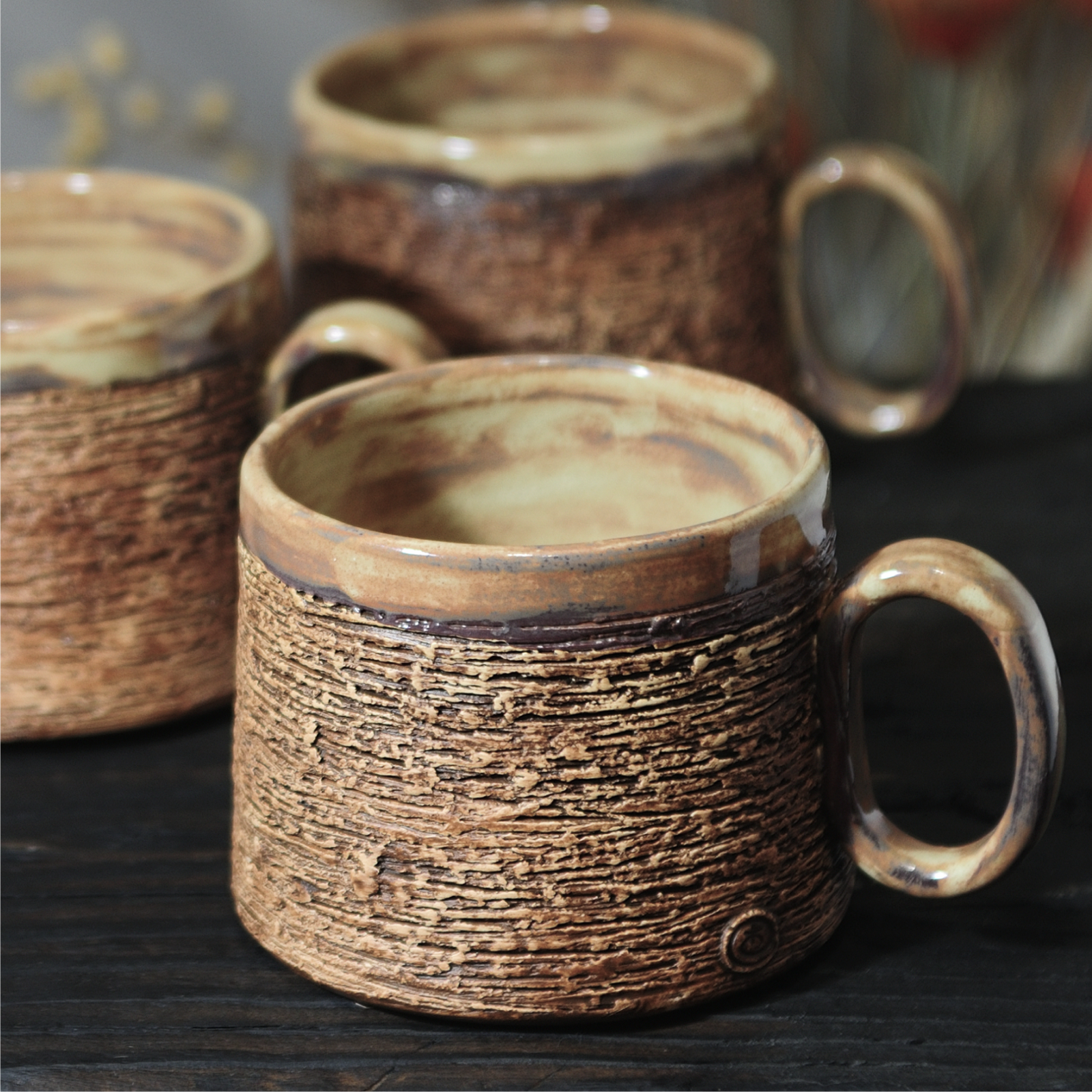 Handmade pottery mug with layered textured surface and handle