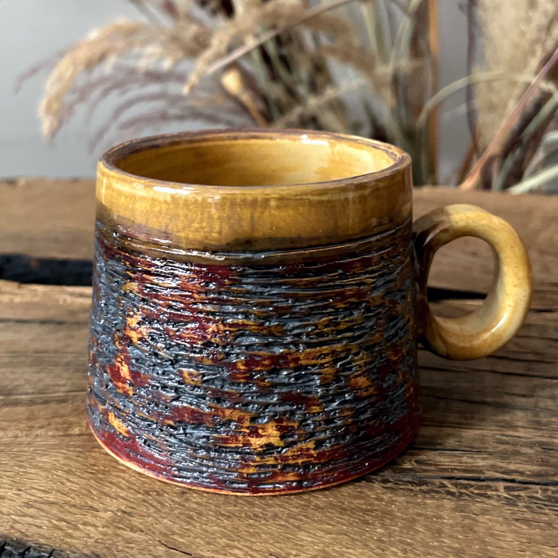 Stoneware espresso cup with textured surface and saucer