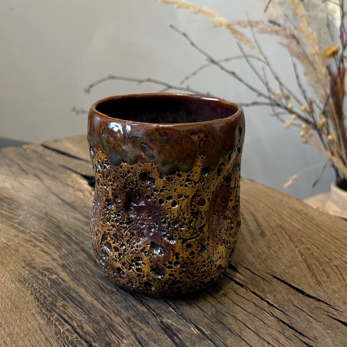 Handmade pottery tea cup with volcanic lava surface texture