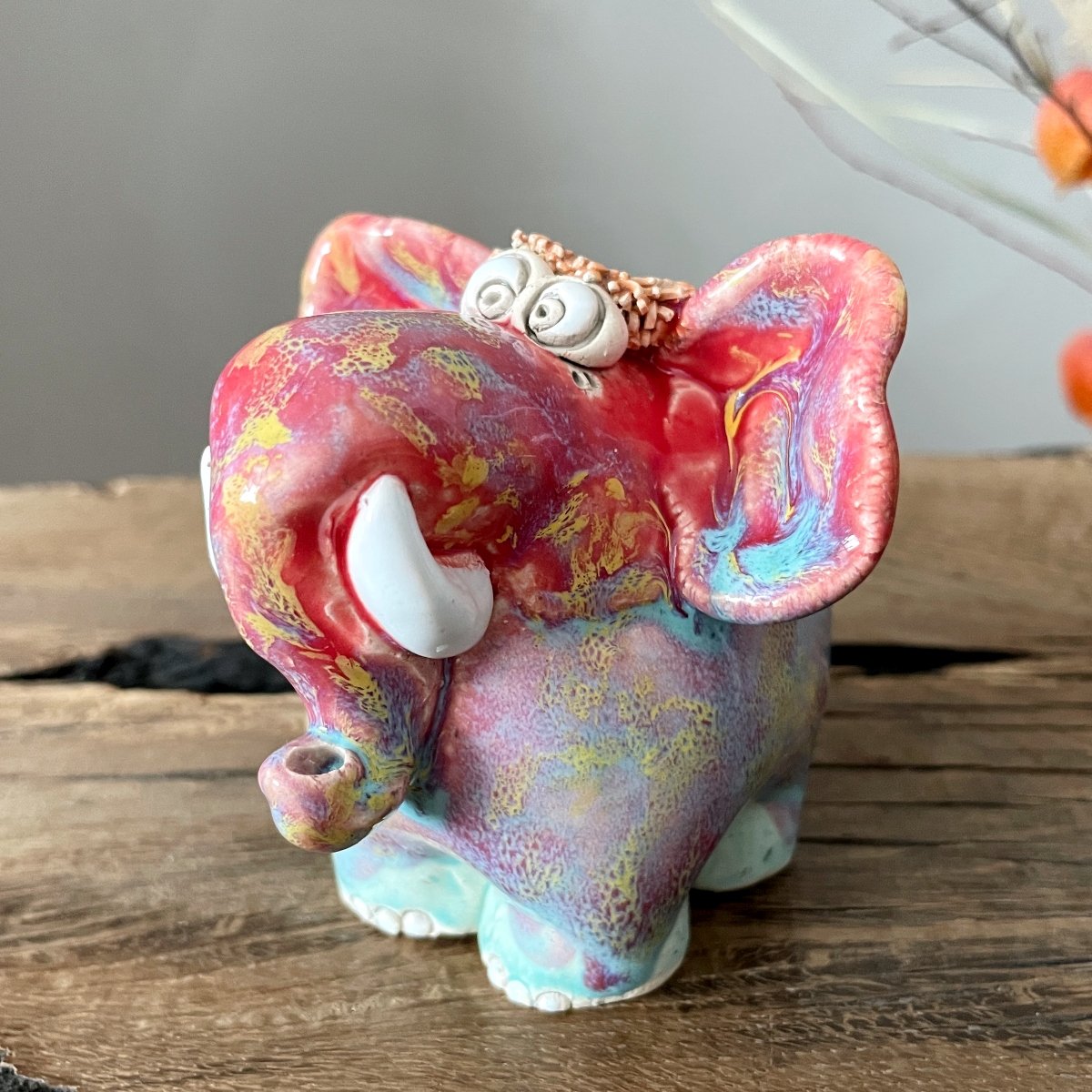 Handmade ceramic elephant figurine with vibrant red and pink marbled glaze finish