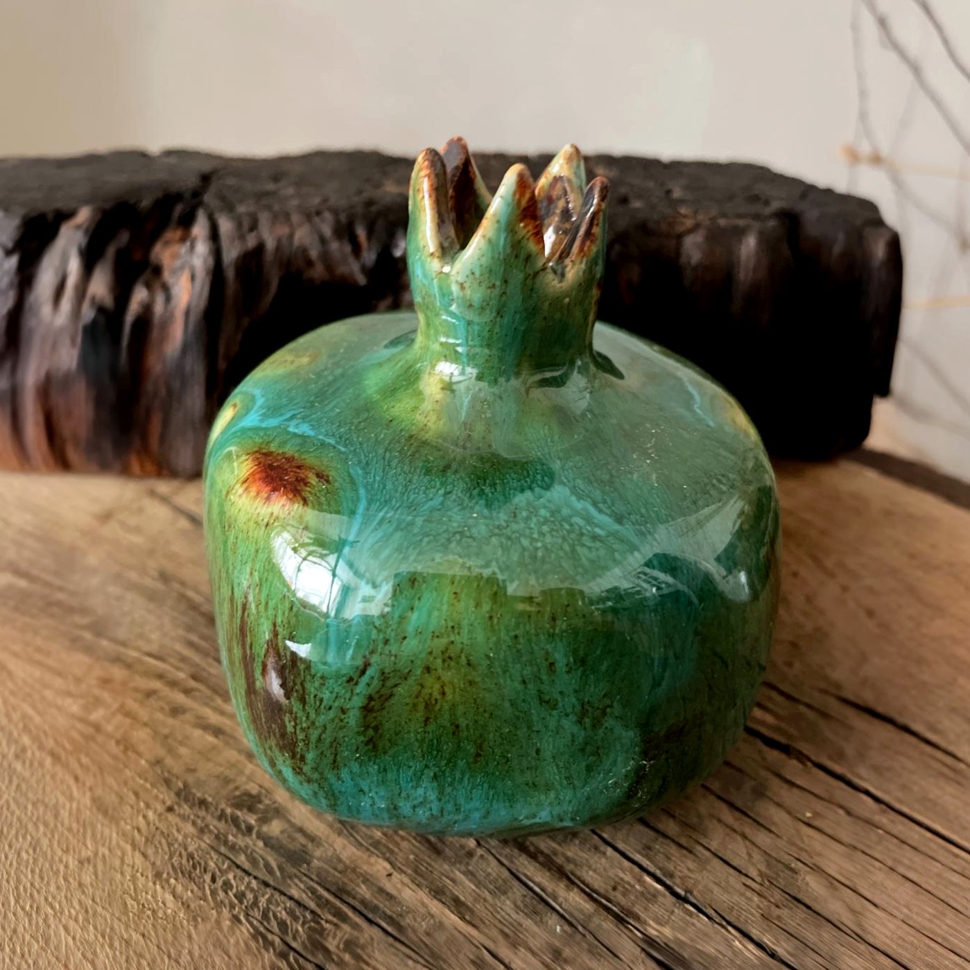 Glossy green pottery pomegranate side view