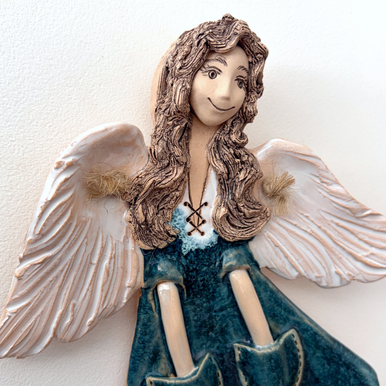 Handmade ceramic angel with white wings, upper body detail