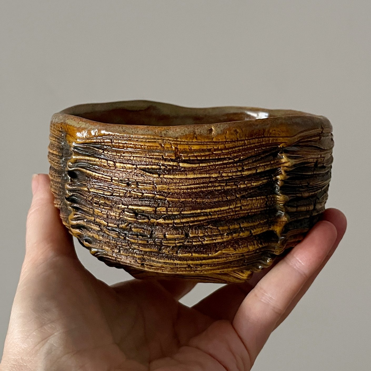 Textured stoneware matcha bowl in warm earth-tone glaze
