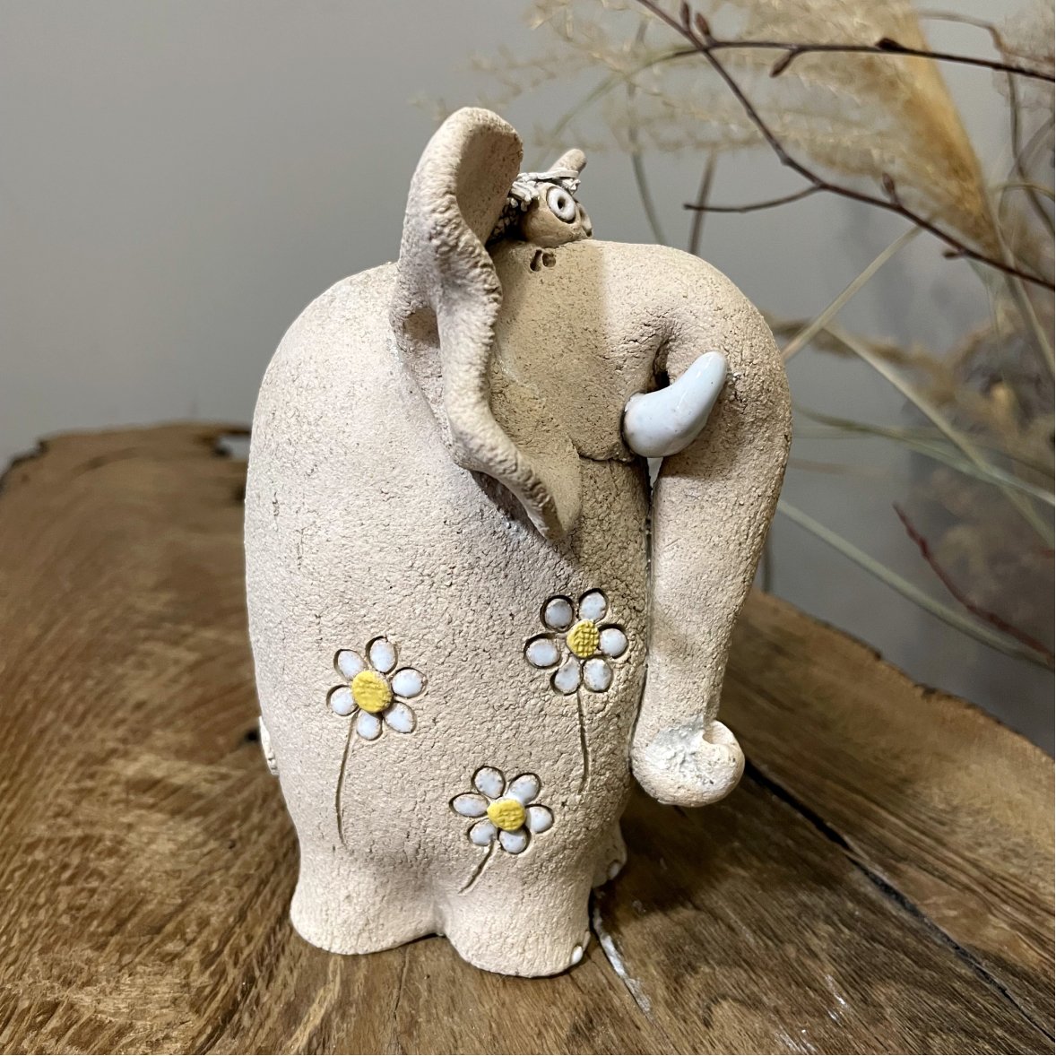 Decorative ceramic elephant sculpture on wooden surface