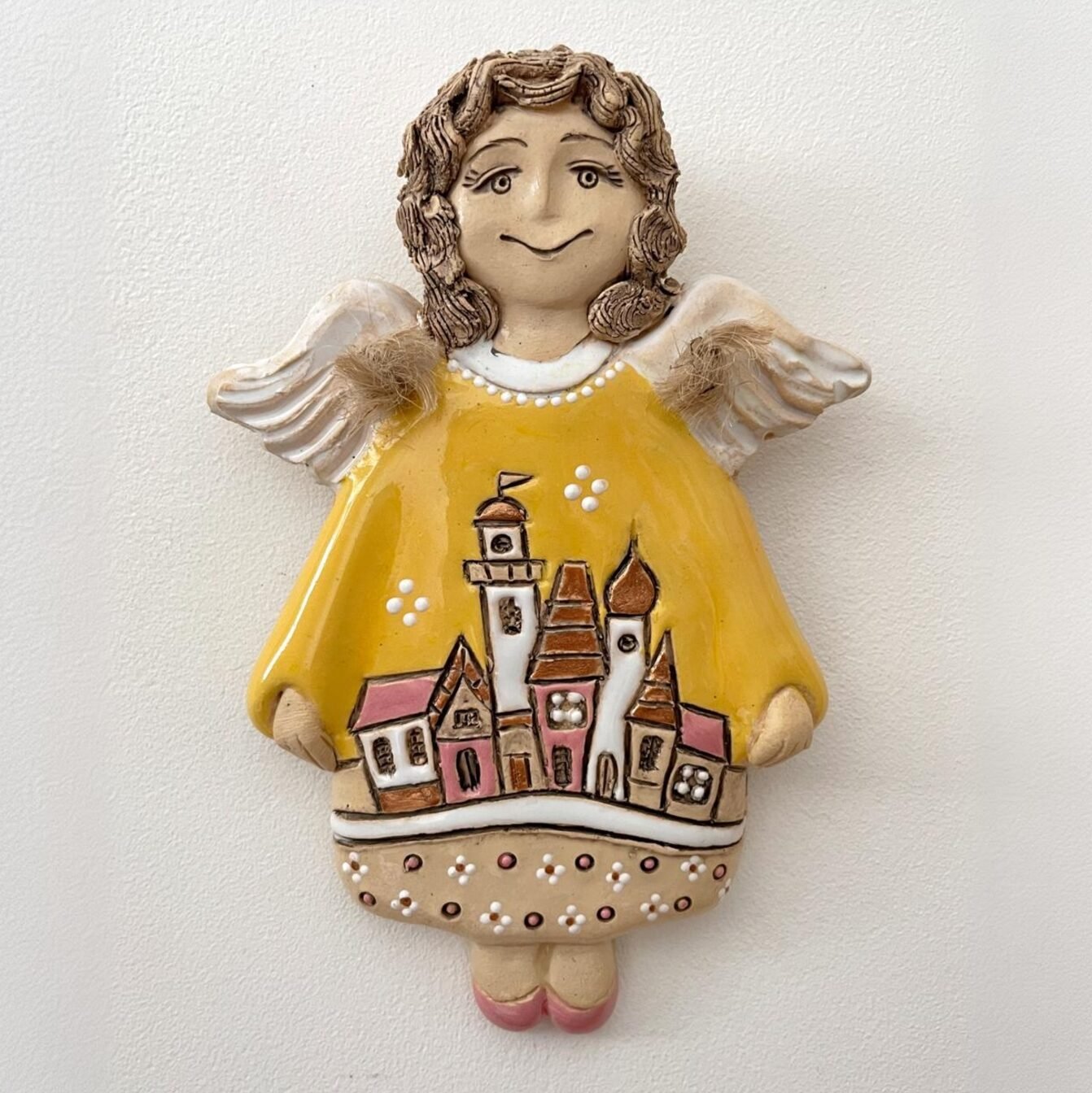 Decorative ceramic angel wall hanging with village illustration
