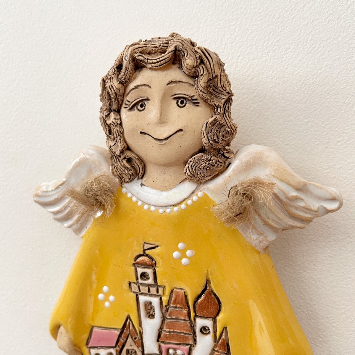Detail of handmade angel wall sculpture with white wings