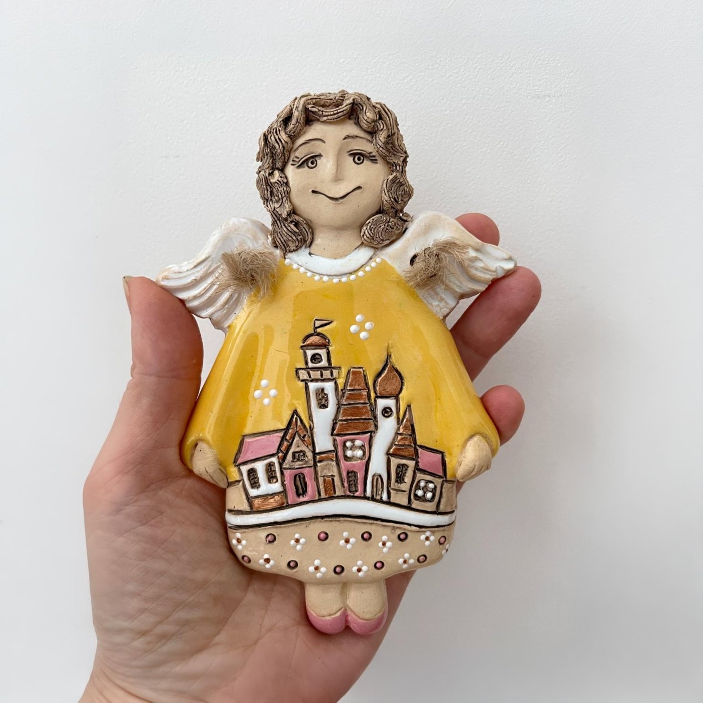 Yellow ceramic angel wall hanging with miniature village