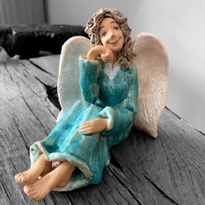 Smiling ceramic angel sculpture with white wings