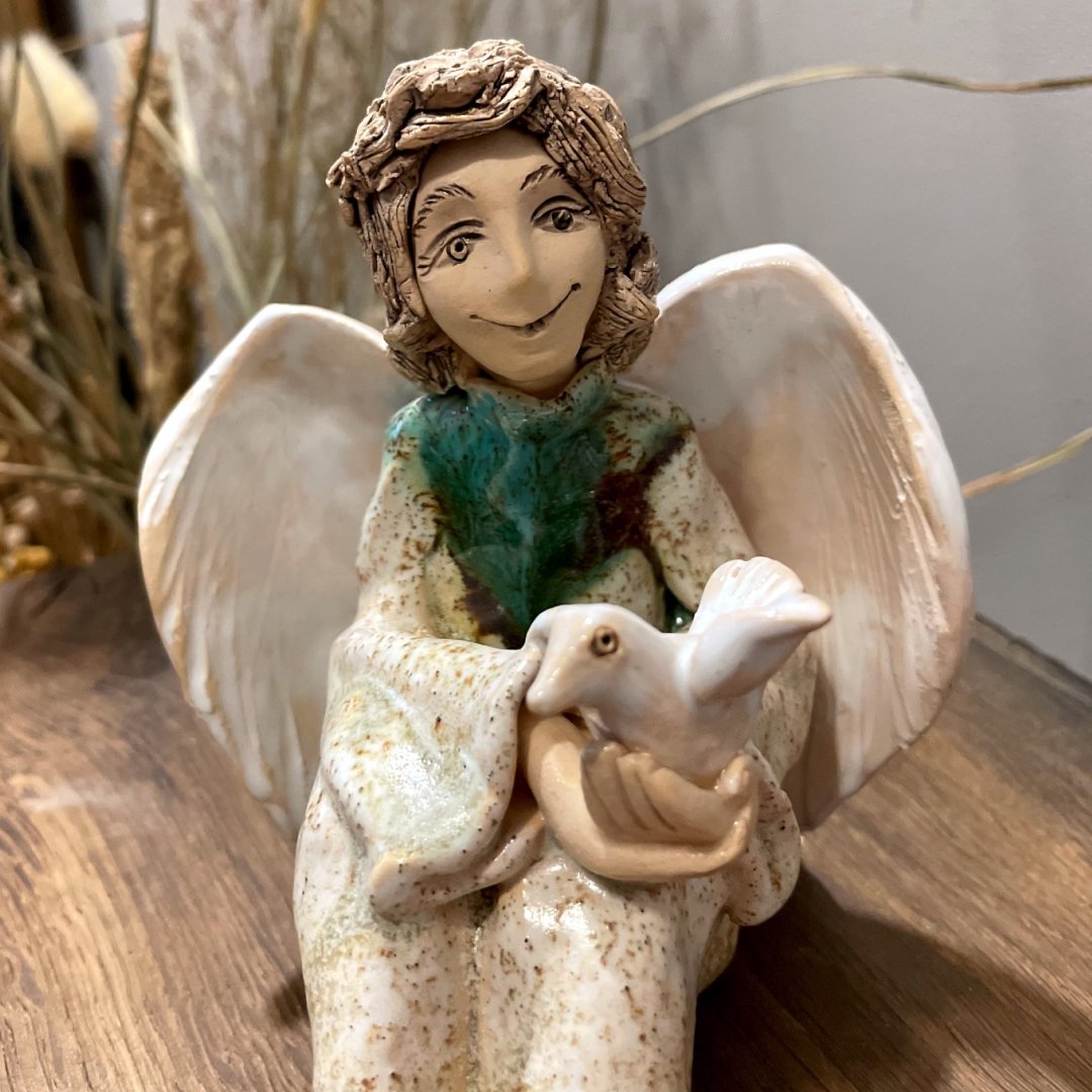 ceramic angel sculpture with white wings