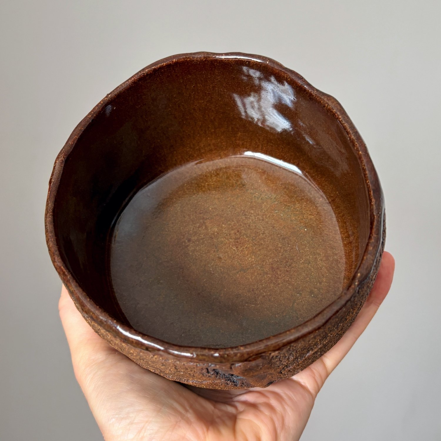 Interior view of artisan pottery bowl showing smooth brown glaze