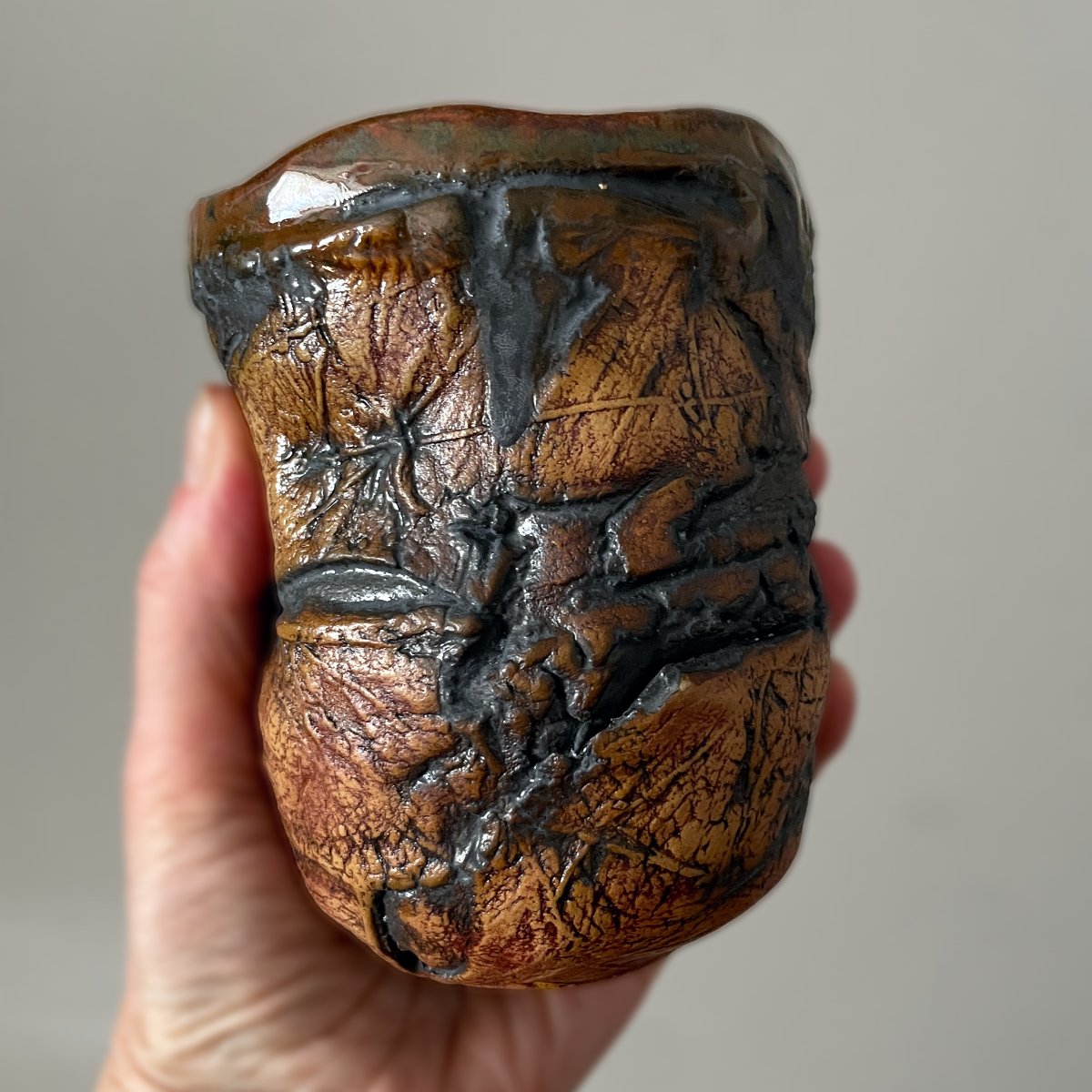 Side view of handmade ceramic yunomi showing sculpted texture