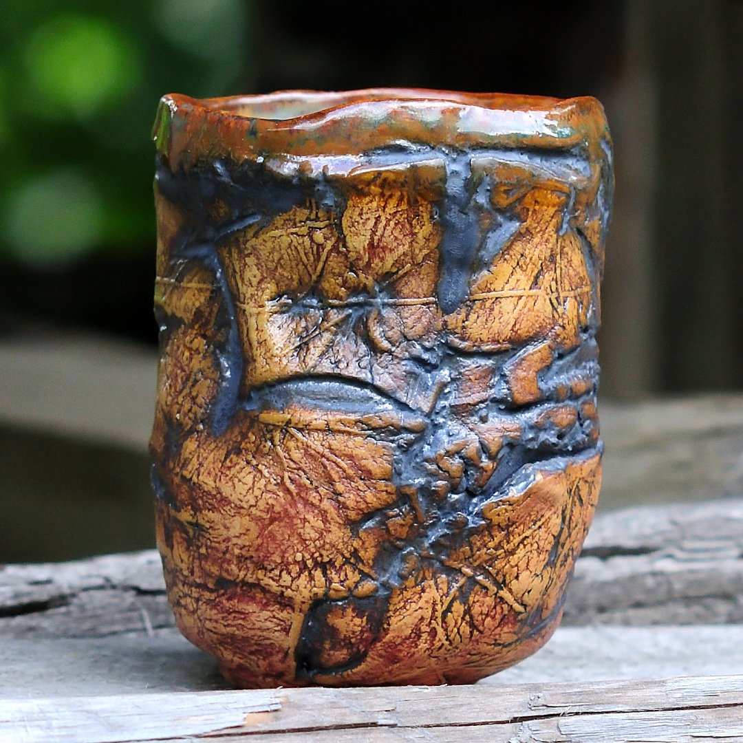 Handmade ceramic yunomi tea cup with textured carved surface