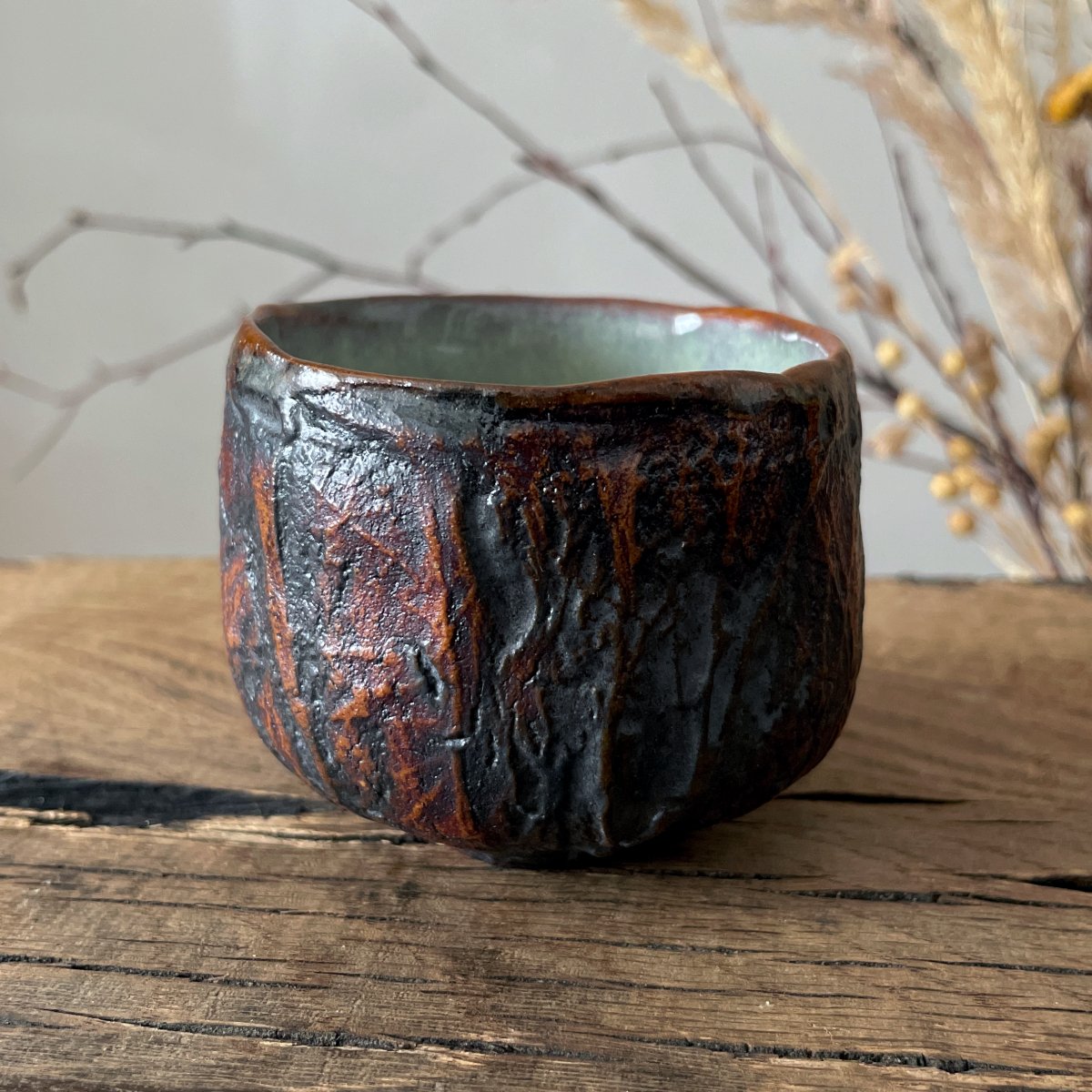 Handmade pottery tea cup showing carved organic texture