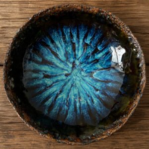 Handmade blue crystal glazed ceramic serving bowl on rustic wooden table