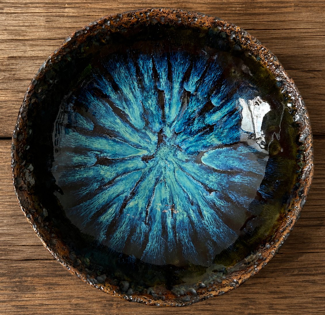 Handmade blue crystal glazed ceramic serving bowl on rustic wooden table