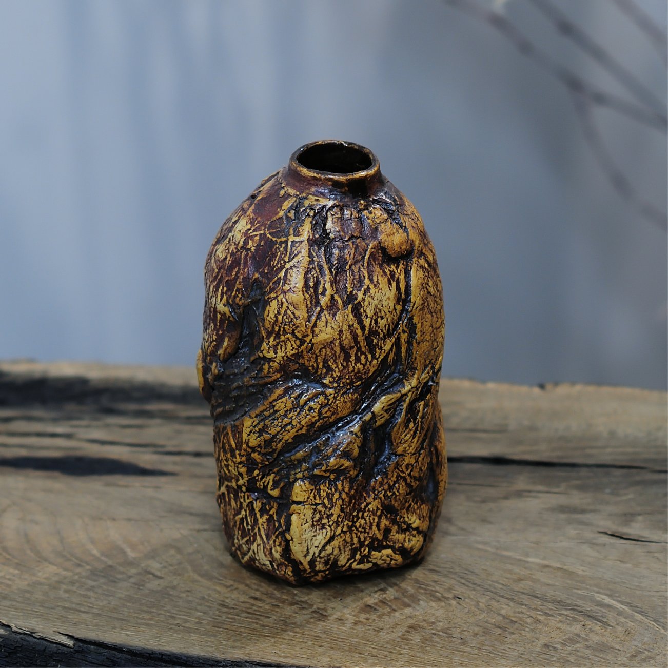 Textured vase with dark red and gold glaze close-up