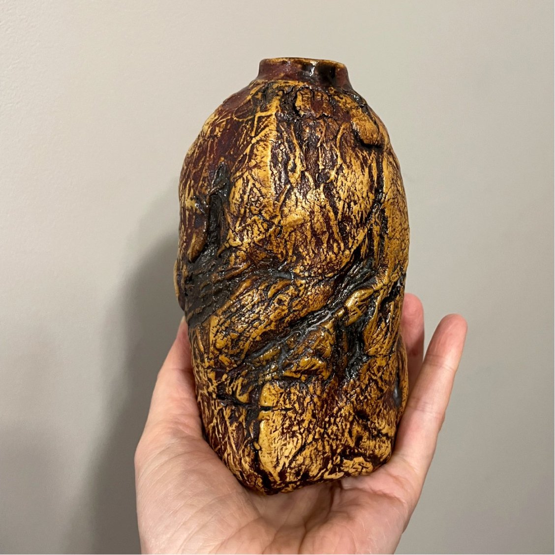 Small sculptural ceramic vase held in hand for scale