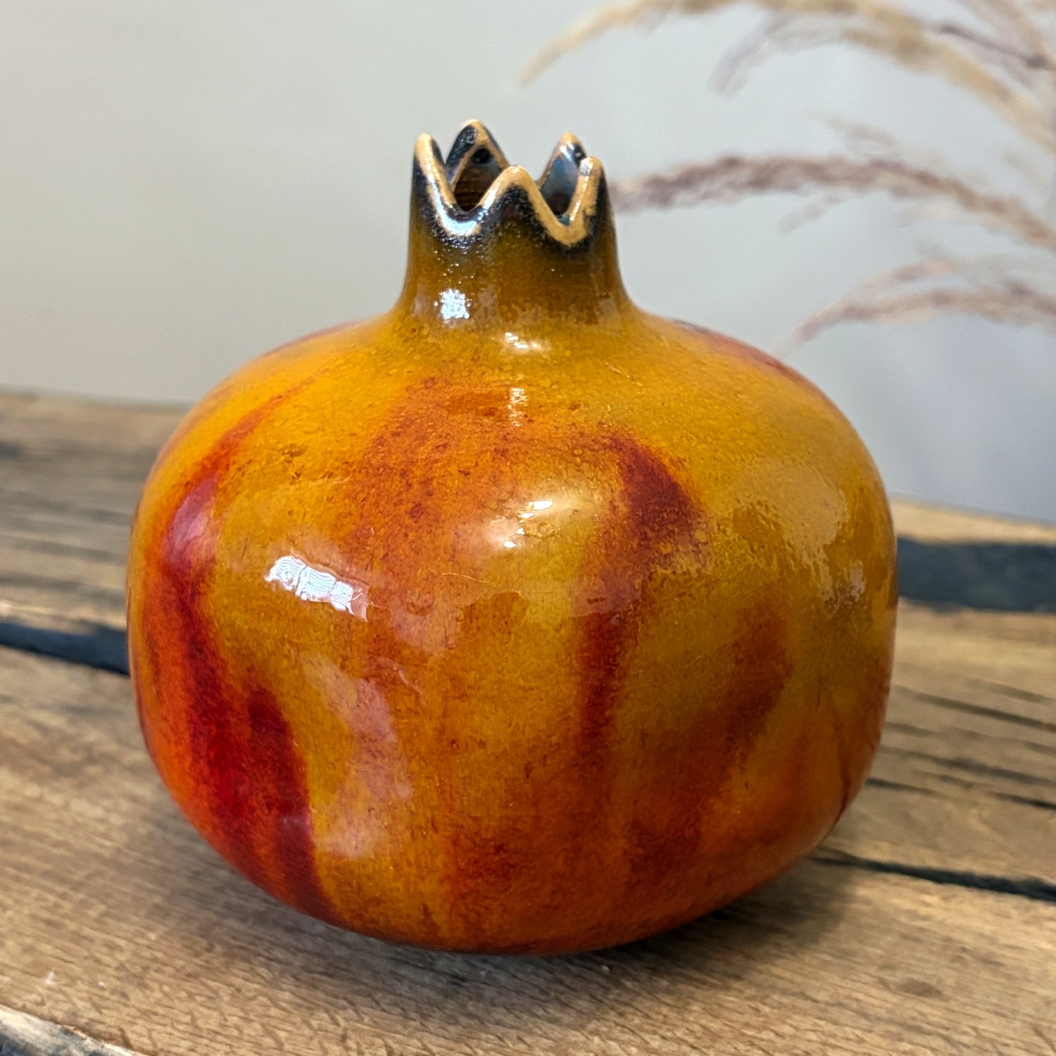 Handcrafted pottery pomegranate with golden yellow and deep red glaze