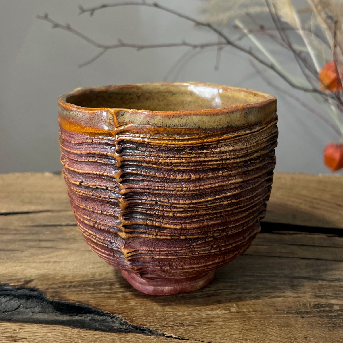Textured stoneware yunomi tea cup in warm earth-tone glaze
