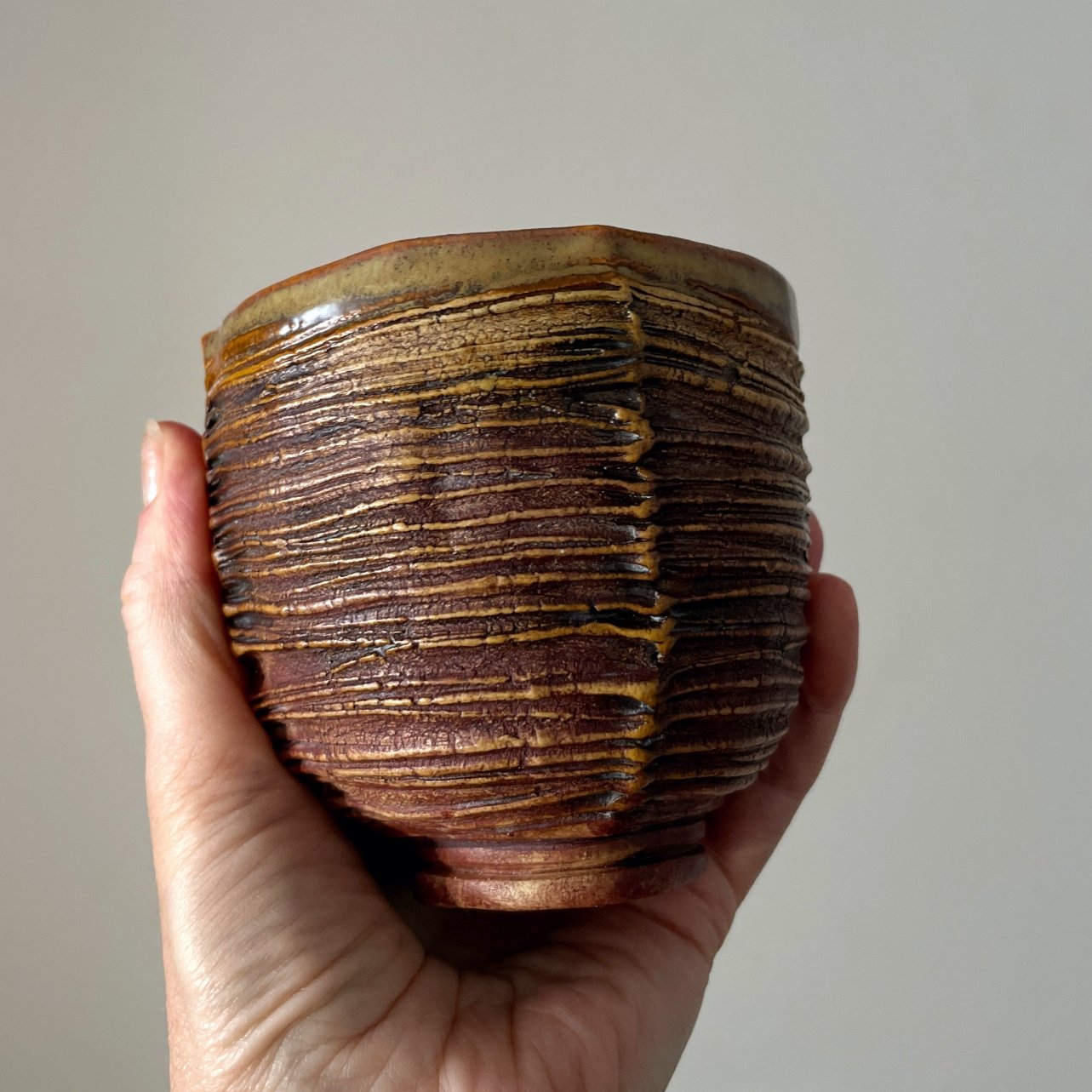 Handmade ceramic cup with faceted form and textured surface